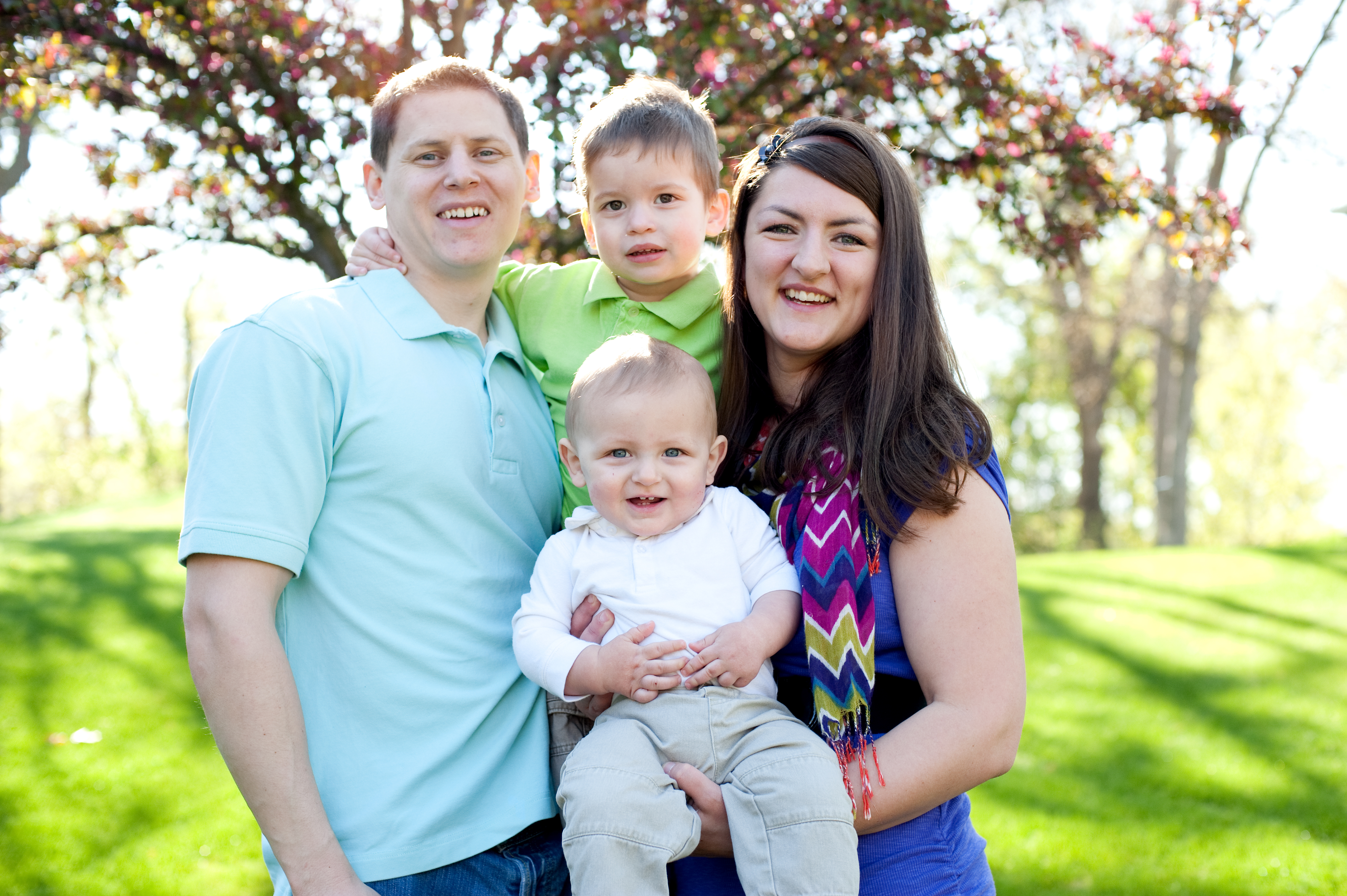 adoptive family built through open adoption pose for a photo under a tree